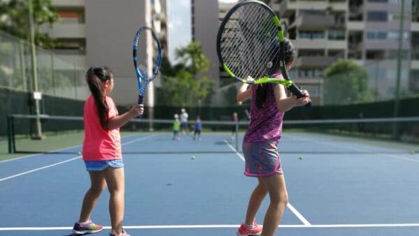 a family playing lawn tennis in a tennis court