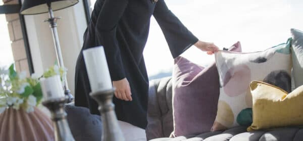a woman who is arranging the sofa for home staging